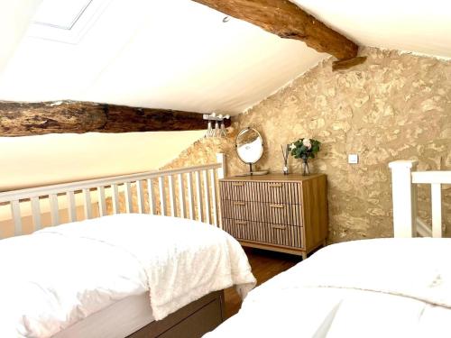 une chambre avec deux lits et un miroir dans l'établissement The Dovecote, à Loubès-Bernac