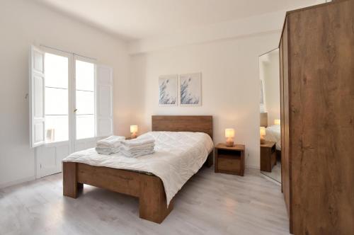 a bedroom with a bed with white sheets and two lamps at Sud Casa Vacanze in Ragusa