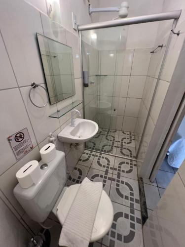 a white bathroom with a toilet and a sink at Espaço Fateixa in Jericoacoara