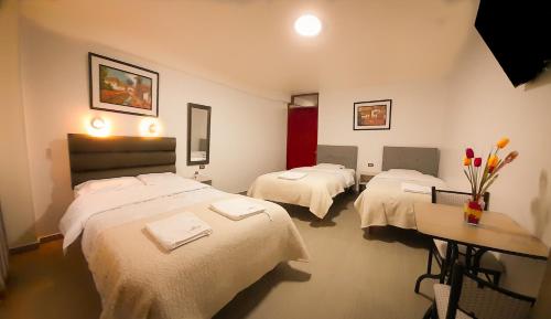 a hotel room with two beds with white sheets at La Rinconada de Churin in Churín