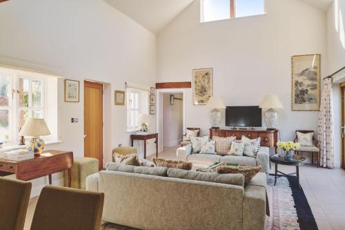 a living room with two couches and a tv at Hockham Grange in Hockham