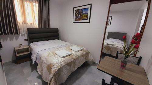 a bedroom with a bed and a table and a mirror at La Rinconada de Churin in Churín