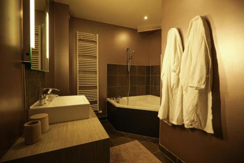 a bathroom with a tub and a sink and a bath tub at Ferme du Roy in Anserville