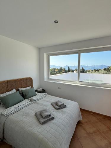 ein Schlafzimmer mit einem großen Bett mit zwei Handtüchern darauf in der Unterkunft Casa Alegria - Holiday home with pool, fitness, sauna in Alcúdia