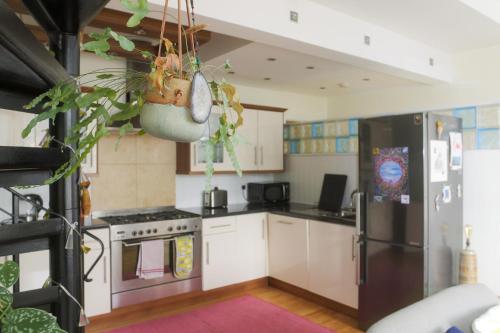 a kitchen with white cabinets and a black refrigerator at Ebrington Street View in Plymouth
