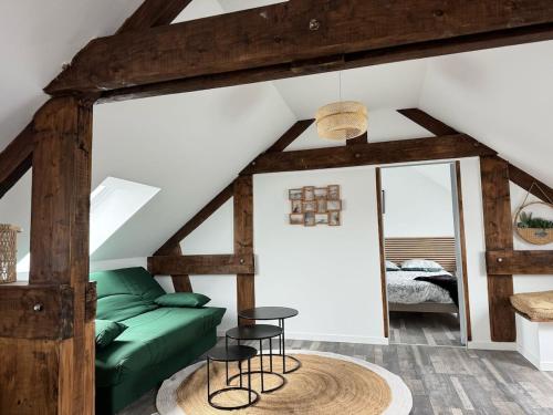 - un salon avec un canapé vert et deux tabourets dans l'établissement Appartement l'écho des remparts, à Boulogne-sur-Mer