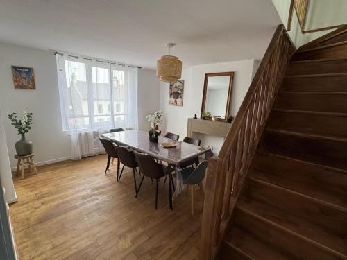 une salle à manger avec une table et des chaises et un escalier dans l'établissement Appartement l'écho des remparts, à Boulogne-sur-Mer