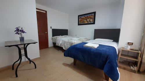 a room with two beds and a table with a bed sidx sidx sidx at La Rinconada de Churin in Churín