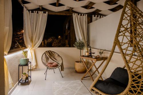 a room with a hammock and a chair on a balcony at Olea Delux Rooms in Zadar