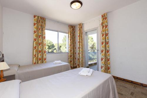 a bedroom with two beds and a window at Rentalmar Los Angeles in Miami Platja