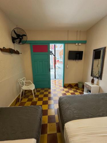 a bedroom with a green door and a checkered floor at CASA HOTEL LAS HORTENSIAS in Jardin