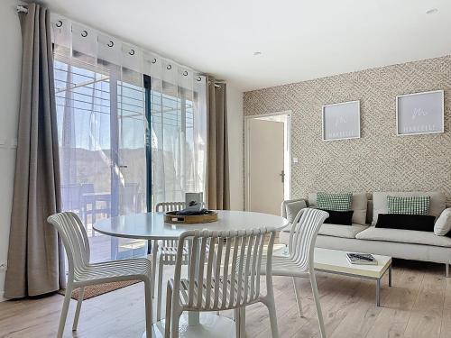 un salon avec une table, des chaises et un canapé dans l'établissement Chalet bois nature et confort, à Banassac