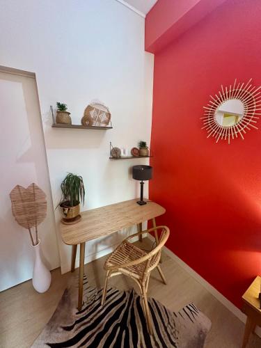 Cette chambre dispose d'une table en bois et d'un mur rouge. dans l'établissement Le Sunlight, Gare Centre ville, 4 Personnes, au Mans