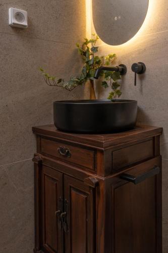 a bathroom sink on a wooden stand with a mirror at GM Appartment in Léntas