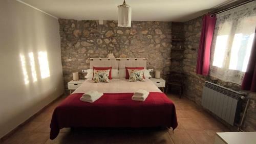 a bedroom with a large bed with red sheets and pillows at Lo Cel De Tolo in Toló