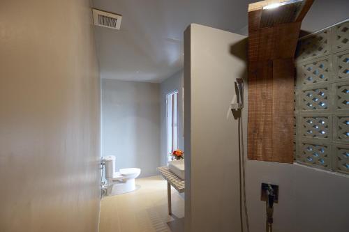 a bathroom with a toilet and a glass door at Goda Boutique Hotel in Hoi An