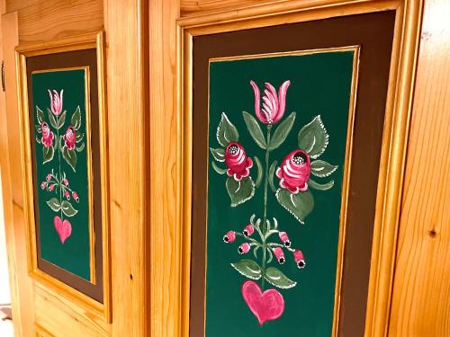 a pair of paintings of flowers on a green wall at Landhaus Weinblick in Rohrendorf bei Krems