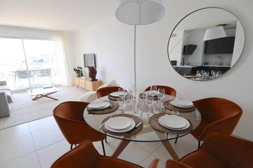 a dining room with a table and chairs and a mirror at Sun Paradise SeaView&Terrace Parking&Pool in Beausoleil