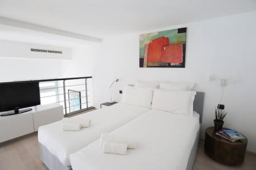 a white bedroom with a bed and a tv at Diodato Luxury Residence Corbusier Promenade & Sea View with Pool #3 in Roquebrune-Cap-Martin
