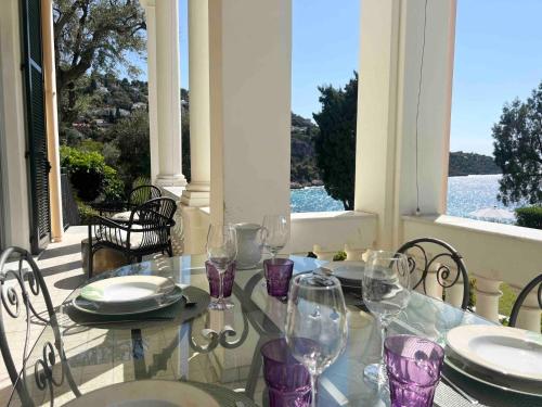 - une table avec des verres à vin assise sur une terrasse couverte dans l'établissement Diodato Luxury Residence Corbusier Promenade & Sea View with Pool #3, à Roquebrune-Cap-Martin