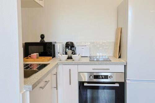 una cucina con fornelli e microonde di La Cachette Centre-Ville a Saint-Étienne