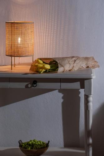 a table with a bowl of green fruit on it at GM Appartment in Léntas