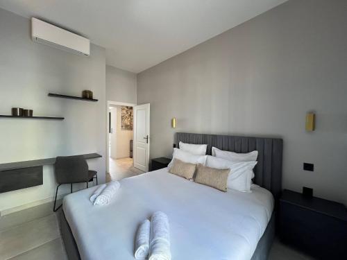 une chambre avec un grand lit blanc avec des serviettes dessus dans l'établissement Menton City Center One Bedroom , Beach & Sea View #15, à Menton