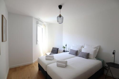 a bedroom with a large white bed and a window at Sun Paradise SeaView&Terrace Parking&Pool in Beausoleil
