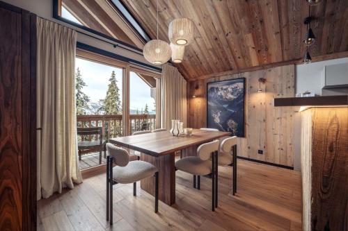 une salle à manger avec une table et des chaises en bois dans l'établissement Antarès URSA 401 - luxury apartment ski inski out, à Méribel
