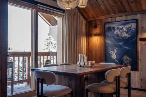 une salle à manger avec une table et des chaises dans l'établissement Antarès URSA 401 - luxury apartment ski inski out, à Méribel