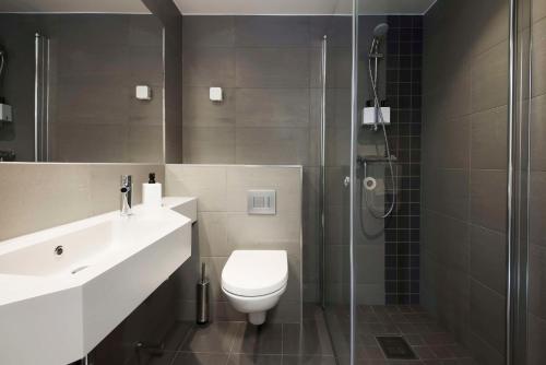 a bathroom with a toilet and a glass shower at Scandic Hamar in Hamar