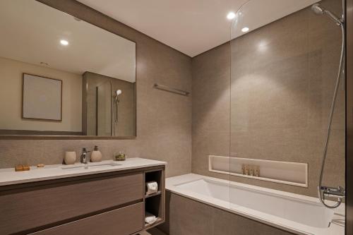 a bathroom with a tub and a sink at Bella Elite Homes at Grande Signature Full Burj and Fountain View Downtown - Brand New Luxury Apartment in Dubai
