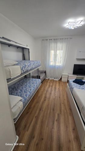a bedroom with two bunk beds and a wooden floor at Bethel House in Gardone Riviera