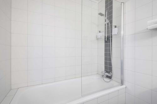 a white bathroom with a shower with a glass door at Scandic Vestfjord Lofoten in Svolvær