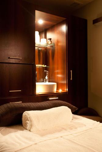 a bathroom with a bed with a sink and a mirror at DoubleTree by Hilton Bristol South - Cadbury House in Yatton