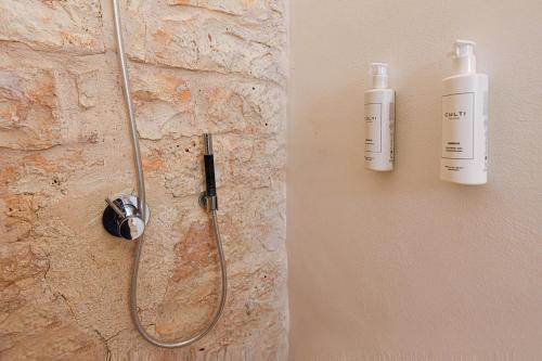a shower with two bottles on the wall at Borgo Elaia in Cisternino