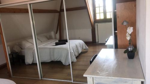 une chambre avec un lit et un miroir dans l'établissement La Tourelle, à Heuringhem