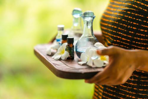a person holding a tray with bottles on it at Pole Pole Bungalows in Utende