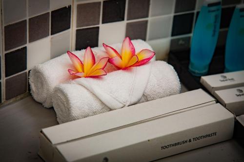 two pink and yellow flowers sitting on top of a box at Hotel Elephant Reach in Yala