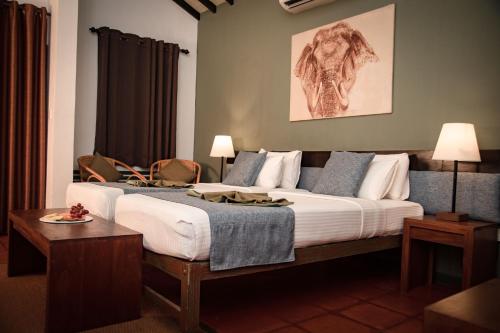 a bedroom with a large bed and a table at Hotel Elephant Reach in Yala