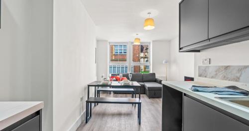 a kitchen and living room with a table and a couch at 2BR Apartment with Sofa bed I Prime Town Centre Location I Gold St D-Lux, Modern Amenities, Walk to Train, Bus Stations, Shops & Cafés I Leisure and Business Stays Welcome in Northampton