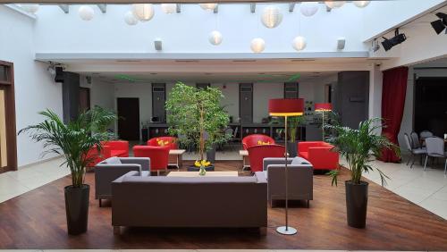 a living room with red furniture and plants at Poleczki Residence Apartments in Warsaw