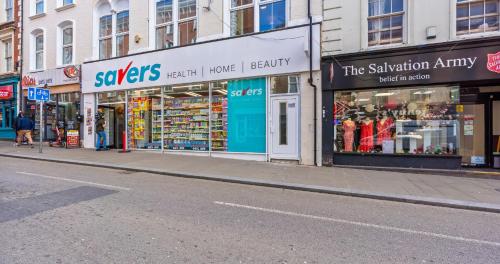 a street with shops on the side of the road at 2BR Apartment with Sofa bed I Prime Town Centre Location I Gold St D-Lux, Modern Amenities, Walk to Train, Bus Stations, Shops & Cafés I Leisure and Business Stays Welcome in Northampton