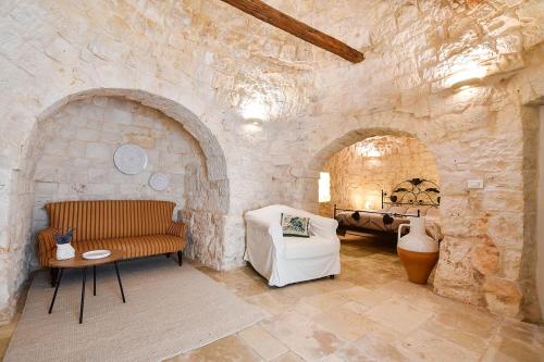 a living room with a stone wall with a couch at Borgo Elaia in Cisternino