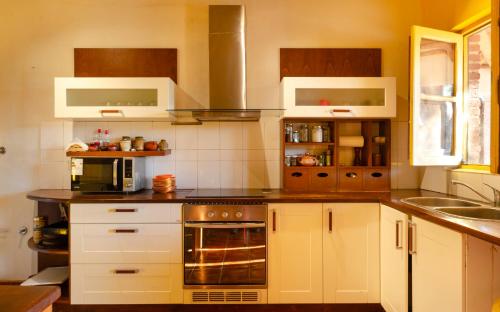 a kitchen with white cabinets and a stove top oven at La Vaca Tranquila in San Carlos