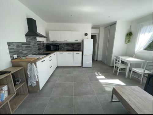 une cuisine avec des armoires blanches et un réfrigérateur blanc dans l'établissement Superbe T2 Porticcio 2 à 4 personnes, à Grosseto-Prugna