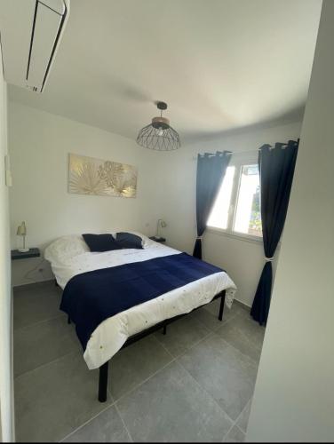 une chambre avec un grand lit avec une couette bleue dans l'établissement Superbe T2 Porticcio 2 à 4 personnes, à Grosseto-Prugna