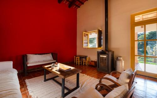 a living room with red walls and a table at La Vaca Tranquila in San Carlos