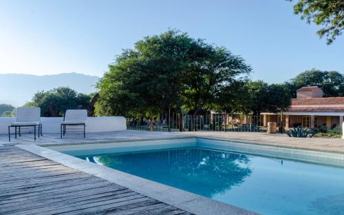 a swimming pool with two chairs and a house at La Vaca Tranquila in San Carlos