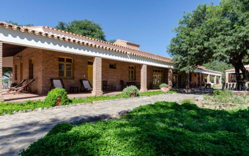 a brick house with a tree in the yard at La Vaca Tranquila in San Carlos